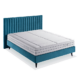 Un cadre de lit en velours bleu sarcelle avec un matelas blanc est élégamment présenté sur un fond uni, rappelant un showroom parisien. Canape Paris by Atelier Bis