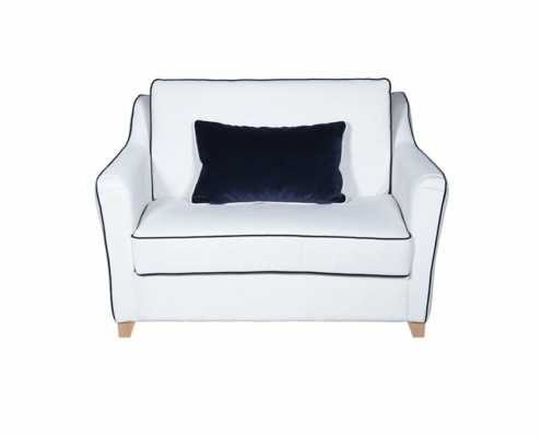 Canapé deux places blanc avec passepoil noir et coussin foncé, rappelant un showroom parisien, sur fond blanc uni. Canape Paris by Atelier Bis