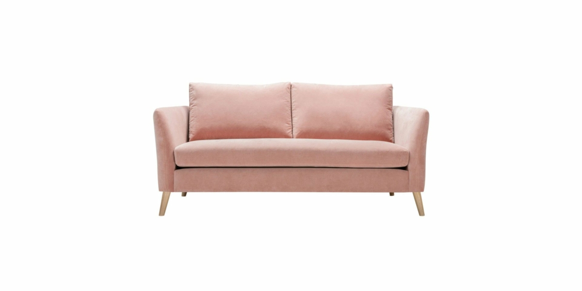 Un canapé chic en velours rose avec des pieds en bois et deux coussins de dossier, rappelant l'élégance parisienne, sur un fond blanc immaculé. Canape Paris by Atelier Bis