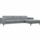 Canapé gris en forme de L au design minimaliste et aux pieds en métal noir, parfait pour tout showroom moderne. Canape Paris by Atelier Bis