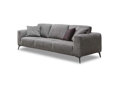 Canapé moderne gris avec trois coussins d'assise, deux coussins gris et un coussin foncé sur fond blanc tel que présenté dans notre showroom parisien. Canape Paris by Atelier Bis