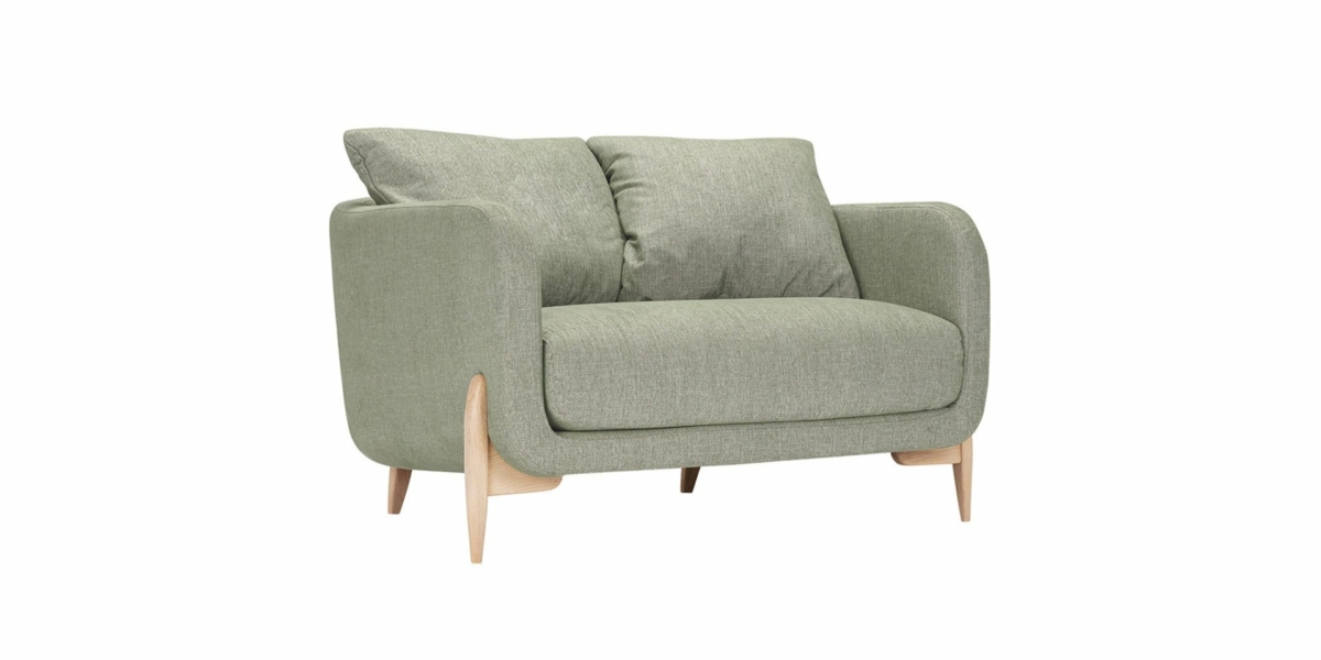 Un canapé élégant et moderne dans un vert luxuriant avec des coussins moelleux et des pieds en bois clair se pose élégamment sur un fond blanc, adapté à n'importe quel showroom parisien. Canape Paris by Atelier Bis