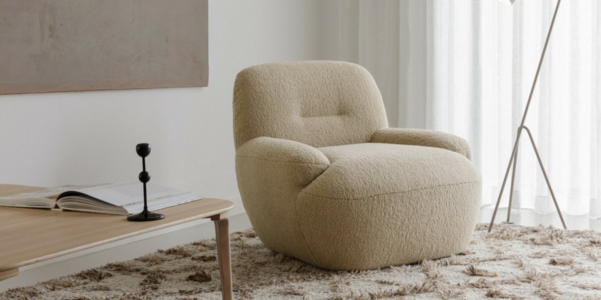 Fauteuil Uma en cuir marron foncé avec des coussins jaunes et blancs Le fauteuil en cuir marron foncé est orné de coussins jaunes et blancs, créant un contraste subtil et élégant dans le salon lumineux.