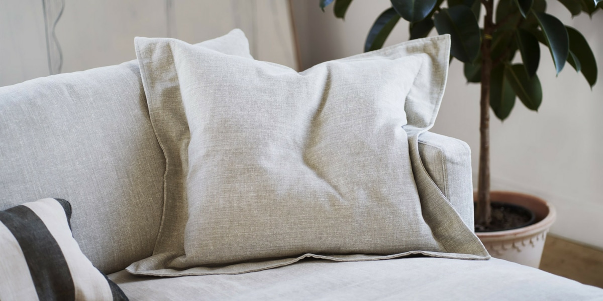 Une décoration chic avec un canapé en velours vert émeraude, des coussins en soie et un lustre élégant.
