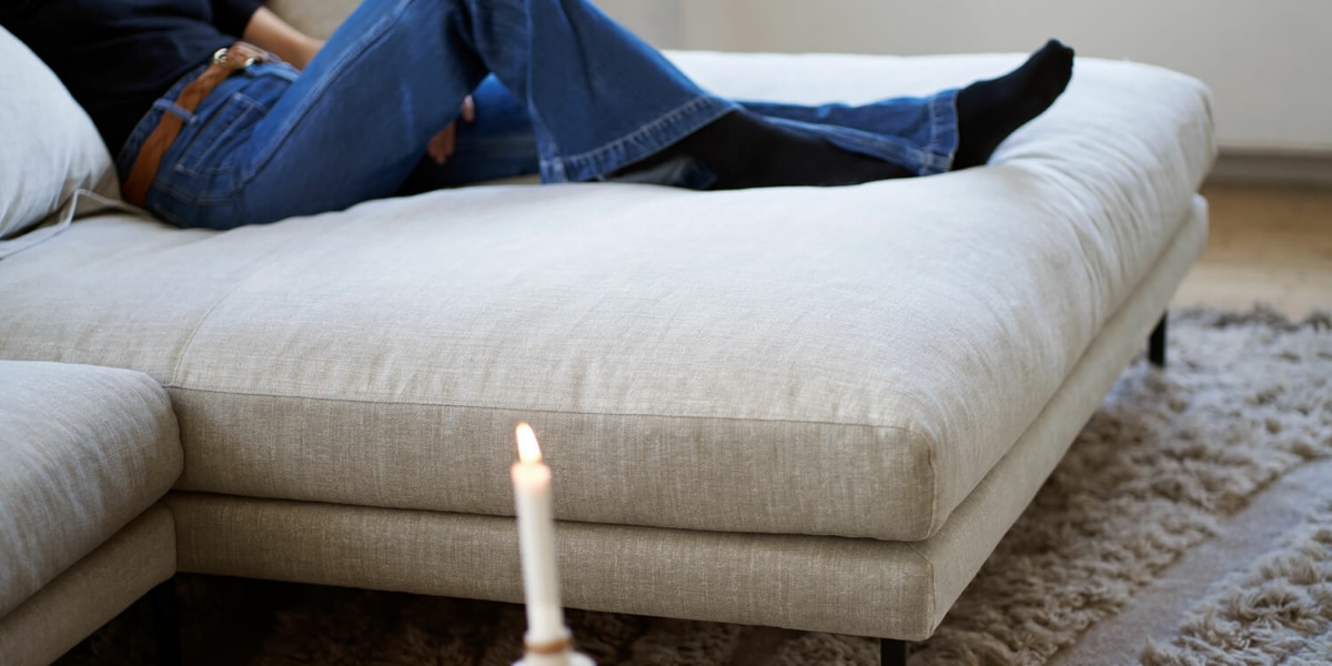 Une décoration élégante avec un canapé en lin beige, des rideaux en lin blanc et des accessoires en métal doré.