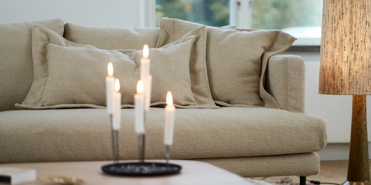 Un espace éclectique avec un canapé en velours rose, des œuvres d'art éclectiques et des meubles dépareillés.