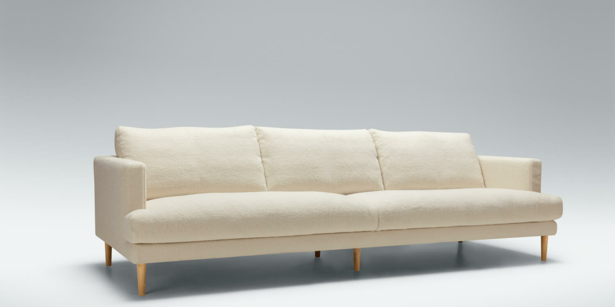 Une décoration minimaliste avec un canapé blanc, un tapis gris clair et des meubles en bois clair.