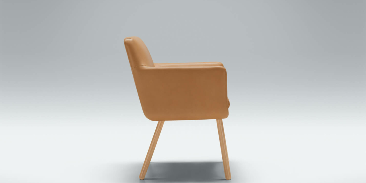 Fauteuil Moa Bistro en cuir cognac avec un tapis à motifs géométriques Le fauteuil en cuir cognac est posé sur un tapis à motifs géométriques, apportant du caractère à un salon contemporain.