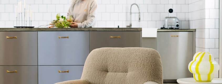 Fauteuil Uma en cuir marron avec une lampe de sol blanche et un vase jaune Le fauteuil en cuir marron est placé à côté d'une lampe de sol blanche et d'un vase jaune, ajoutant une touche moderne et lumineuse à l'espace.