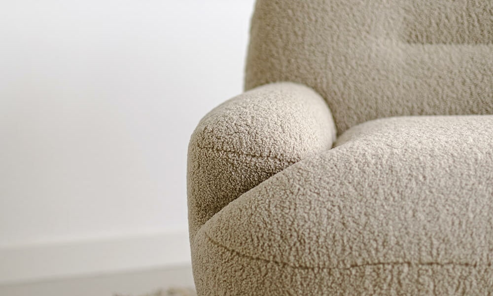 Fauteuil Uma en cuir marron avec un tapis jaune à motifs géométriques Le fauteuil en cuir marron se trouve sur un tapis jaune à motifs géométriques, créant un contraste vibrant et moderne.Le fauteuil en tissu jaune moutarde est agrémenté de coussins marron, apportant une touche chaleureuse et accueillante au salon.