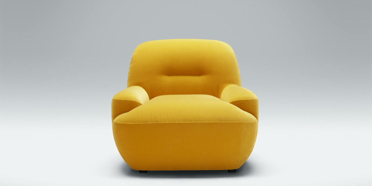 Fauteuil Uma en tissu jaune moutarde avec des coussins marron Le fauteuil en tissu jaune moutarde est agrémenté de coussins marron, apportant une touche chaleureuse et accueillante au salon.