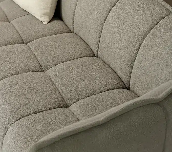 Une image du canapé Clyde gris accompagné d'une table basse en bois et de lampes de style industriel pour une ambiance urbaine et contemporaine.