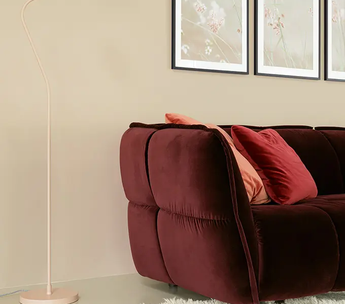 Une image du canapé rose dans un intérieur scandinave avec des tons neutres et des accents de couleur pastel pour une ambiance douce et apaisante.