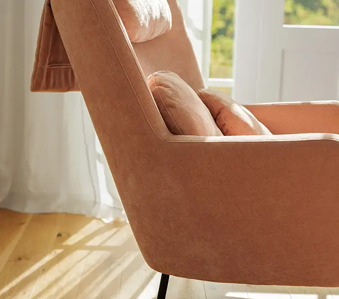 Gros plan sur les coussins du fauteuil Paris, mettant en valeur la texture douce du tissu.