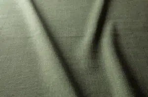 Gros plan sur un tissu vert aux plis souples et diagonaux et à la surface texturée. Canape Paris by Atelier Bis