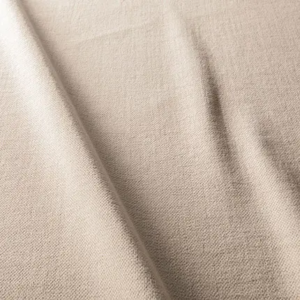 Gros plan sur un tissu beige texturé dont la trame est visible et les plis souples. Canape Paris by Atelier Bis