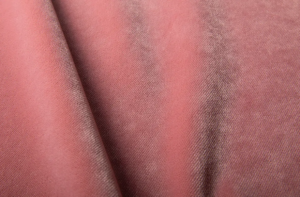 Gros plan sur un tissu texturé rose et doux, aux plis délicats et à la brillance subtile. Canape Paris by Atelier Bis
