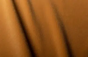 Gros plan sur un tissu brun aux plis souples et diagonaux et à la surface subtilement texturée. Canape Paris by Atelier Bis