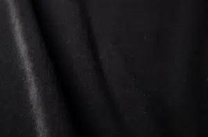 Gros plan sur un tissu noir lisse aux plis délicats et à la texture douce. Canape Paris by Atelier Bis
