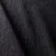 Gros plan d'un tissu denim foncé avec une texture de tissage visible et des ombres diagonales douces sur la surface. Canape Paris by Atelier Bis