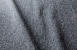 Gros plan sur un tissu gris texturé aux plis souples et aux ombres subtiles. Canape Paris by Atelier Bis