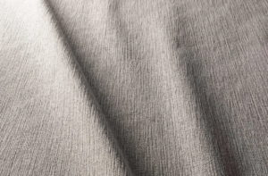 Gros plan d'un tissu texturé gris clair avec des plis doux et un motif de tissage visible. Canape Paris by Atelier Bis