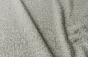 Gros plan sur un tissu beige texturé avec des plis et des ombres subtiles. Canape Paris by Atelier Bis