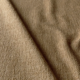 Gros plan d'un tissu beige texturé avec des plis visibles en diagonale. Canape Paris by Atelier Bis
