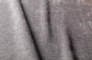 Gros plan sur un tissu texturé gris aux plis subtils et au motif de tissage visible. Canape Paris by Atelier Bis