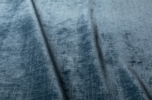 Tissu bleu texturé avec des ombres et des plis subtils qui traversent la surface en diagonale. Canape Paris by Atelier Bis