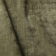 Gros plan sur un tissu texturé vert olive, légèrement brillant et aux plis visibles. Canape Paris by Atelier Bis