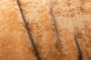 Gros plan sur un tissu de velours brun texturé, aux plis visibles et à la surface douce et brillante. Canape Paris by Atelier Bis