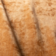Gros plan sur un tissu de velours brun texturé, aux plis visibles et à la surface douce et brillante. Canape Paris by Atelier Bis