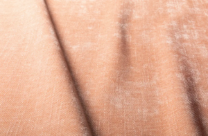Gros plan sur un tissu de velours doux, brun clair, dont la texture et les plis sont visibles. Canape Paris by Atelier Bis