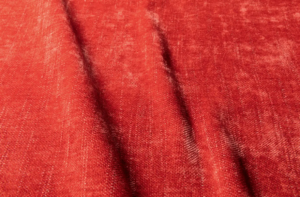 Gros plan sur un tissu rouge texturé, aux plis souples et à l'aspect légèrement usé. Canape Paris by Atelier Bis
