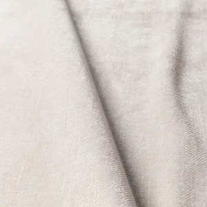 Gros plan sur un tissu beige clair à la texture douce et au pli diagonal subtil. Canape Paris by Atelier Bis