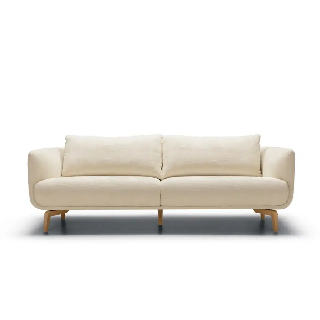 Canapé moderne à deux places, de couleur crème, avec des coussins moelleux et des pieds en bois, sur fond blanc. Canape Paris by Atelier Bis