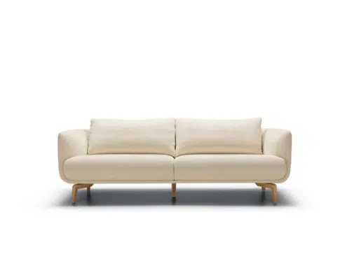 Canapé moderne à deux places, de couleur crème, avec des coussins moelleux et des pieds en bois, sur fond blanc. Canape Paris by Atelier Bis