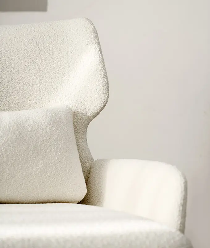 Gros plan sur un fauteuil moderne blanc texturé avec un coussin rectangulaire assorti. Canape Paris by Atelier Bis